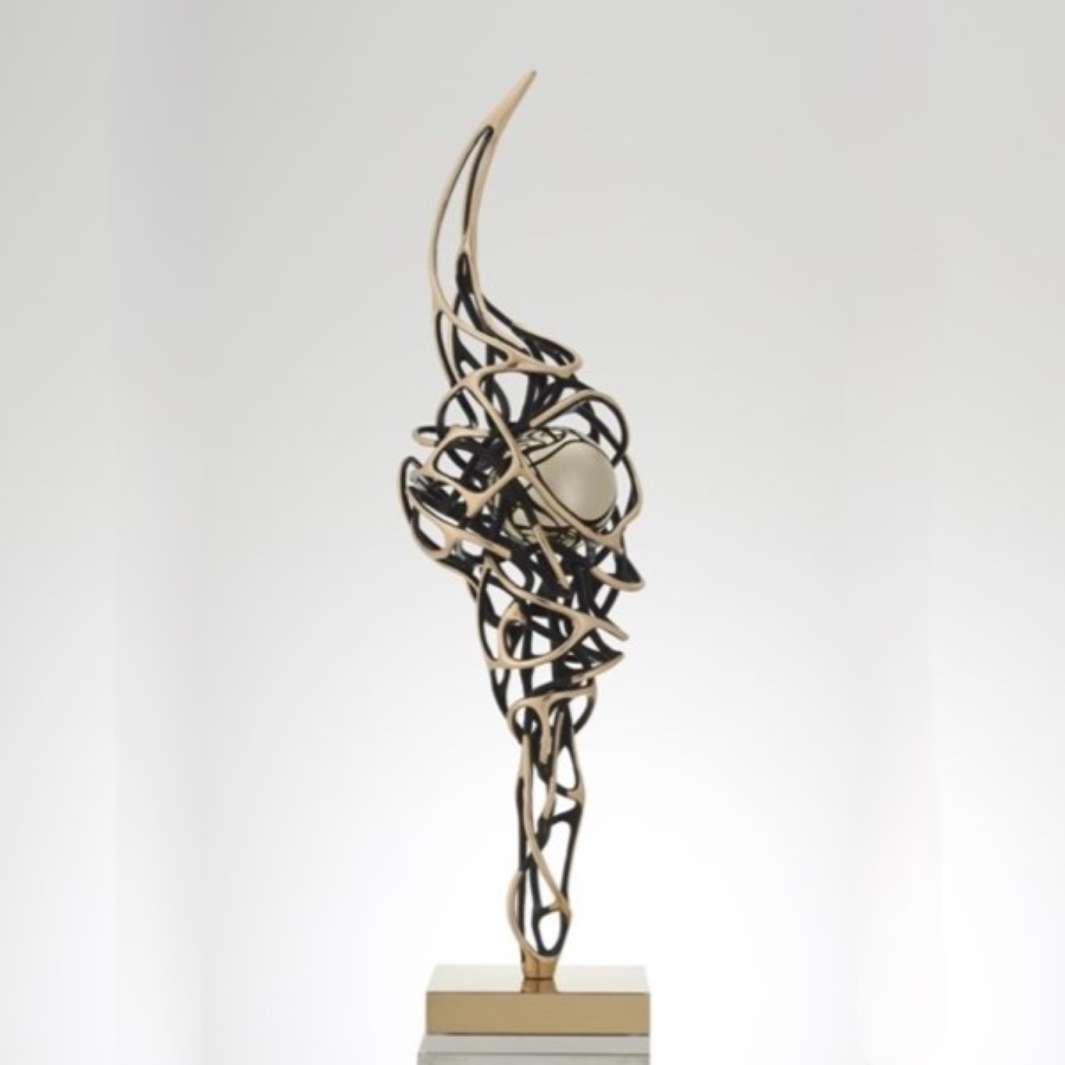 A dynamic bronze sculpture by Gianfranco Meggiato, depicting a bird with outstretched wings, symbolizing freedom and energy, positioned against a clear blue sky.